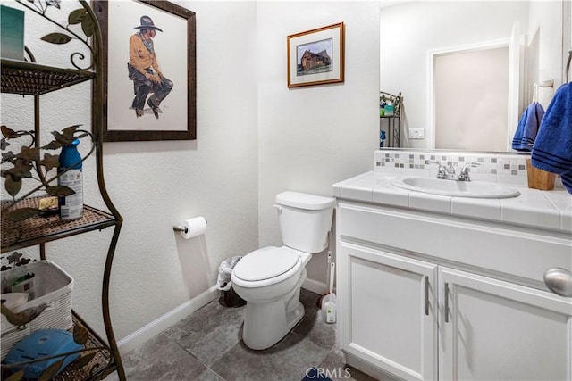 bathroom featuring toilet, baseboards, decorative backsplash, and vanity