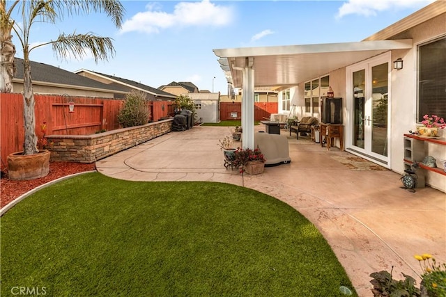 view of yard with a patio area, a fenced backyard, an outdoor hangout area, and french doors