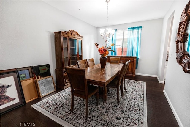 dining space with an inviting chandelier, baseboards, and dark wood-style flooring