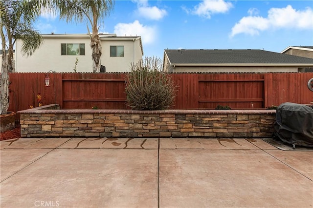 view of patio featuring grilling area and fence