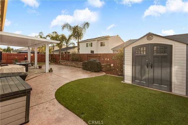 view of yard featuring a patio area, a fenced backyard, a storage shed, and an outdoor structure