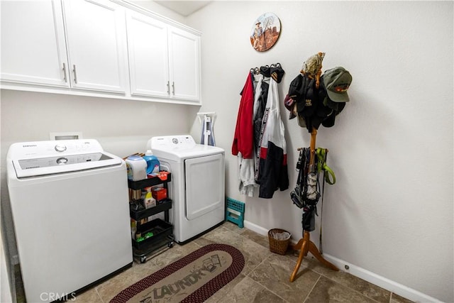 laundry area featuring washer and clothes dryer, cabinet space, and baseboards