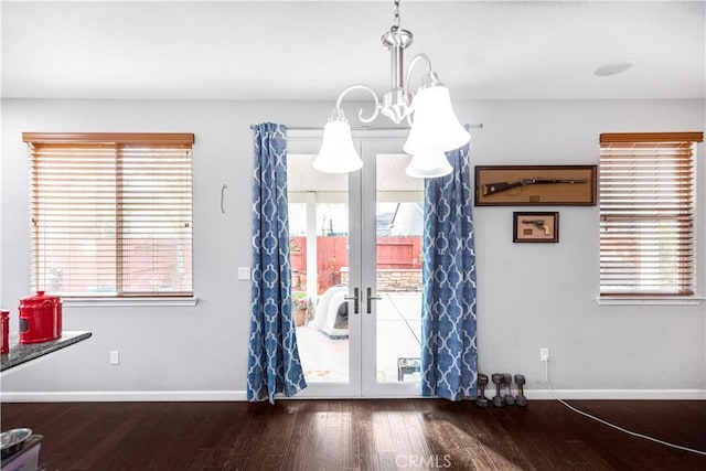 unfurnished dining area with baseboards, wood finished floors, and a healthy amount of sunlight