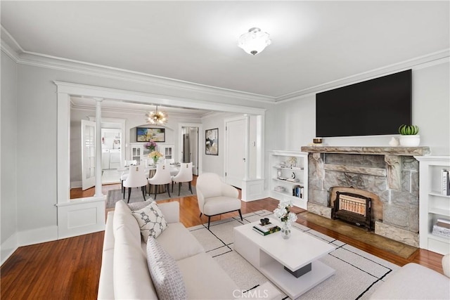 living room with a fireplace, crown molding, and wood finished floors