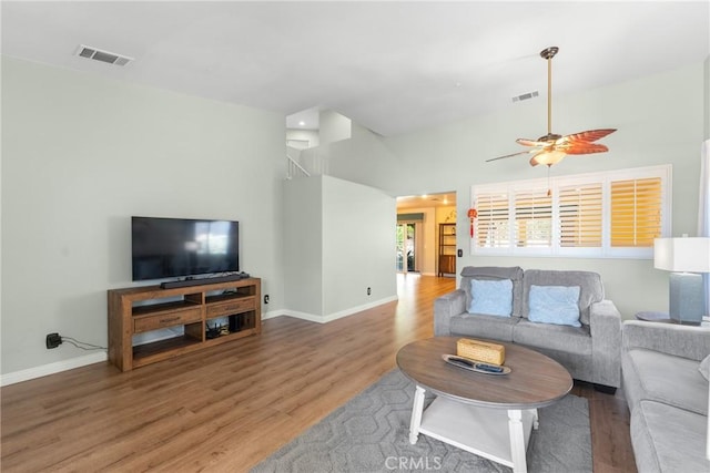 living area with visible vents, baseboards, and wood finished floors