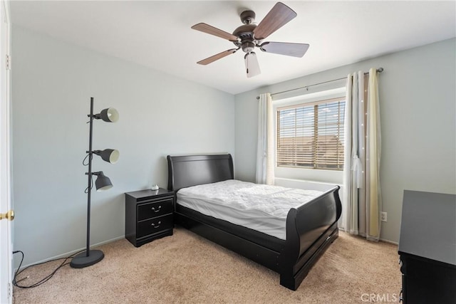 bedroom featuring light colored carpet, ceiling fan, and baseboards