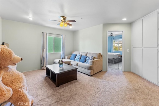 living room with light carpet, ceiling fan, and plenty of natural light