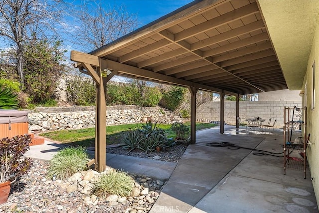 view of patio / terrace featuring a hot tub and a fenced backyard