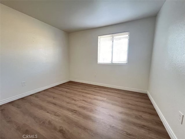 empty room featuring baseboards and wood finished floors