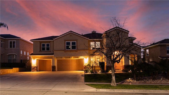 view of front of home featuring a chimney, stucco siding, concrete driveway, an attached garage, and stone siding