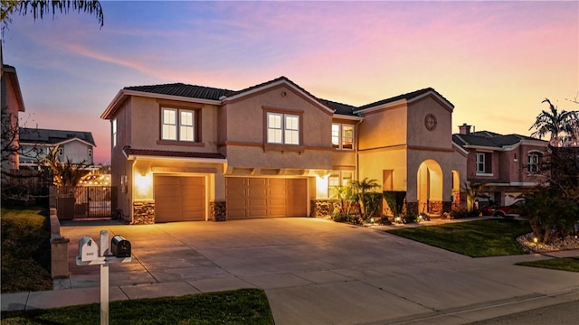 view of front facade featuring stucco siding, driveway, fence, a yard, and an attached garage