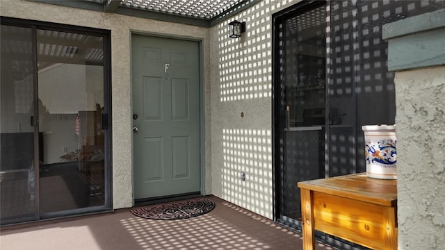 entrance to property featuring a tiled roof and stucco siding