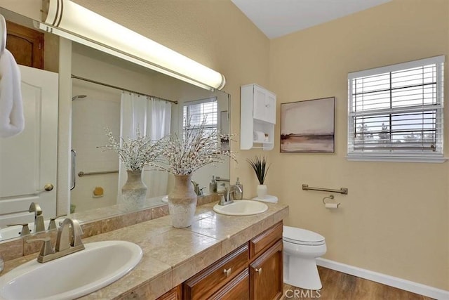 bathroom featuring a sink, toilet, curtained shower, and wood finished floors