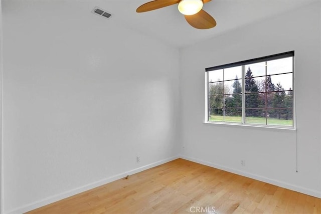 spare room with visible vents, a ceiling fan, light wood-style floors, and baseboards