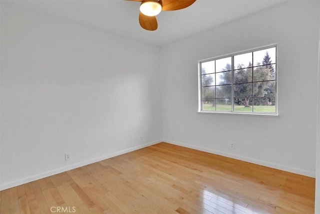 spare room featuring baseboards, ceiling fan, and light wood-style flooring