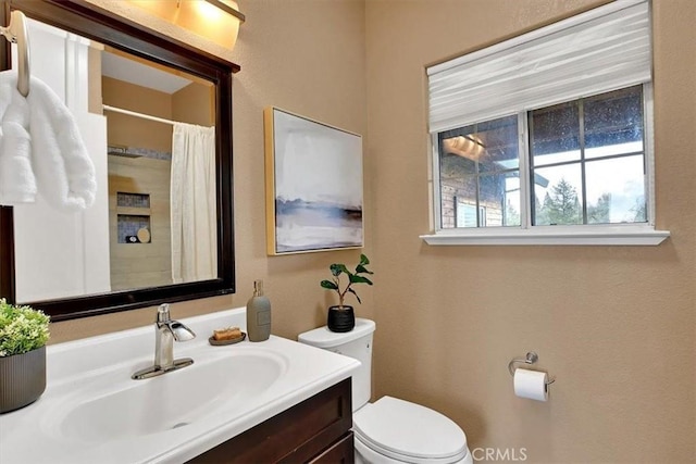 bathroom featuring vanity, a shower with shower curtain, and toilet