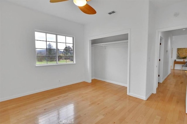 unfurnished bedroom with visible vents, a closet, baseboards, ceiling fan, and light wood-style flooring