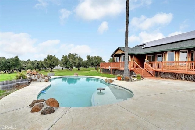 outdoor pool with a yard, a patio, and a wooden deck