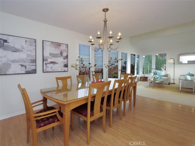 dining area featuring baseboards, a notable chandelier, and light wood-style floors