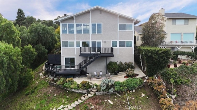 rear view of property featuring stucco siding, stairway, a patio, and a wooden deck