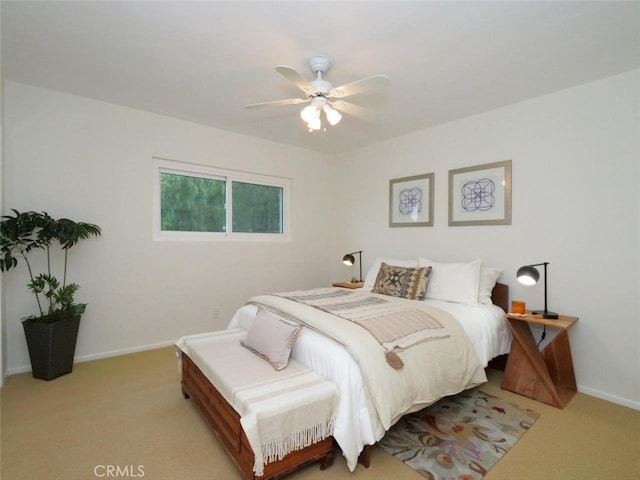 bedroom with ceiling fan, light colored carpet, and baseboards