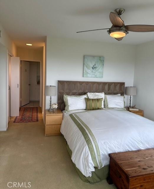 bedroom with ceiling fan and light colored carpet