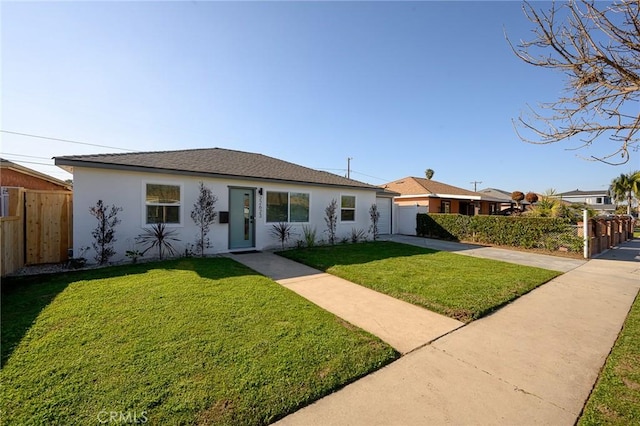 ranch-style home with a front yard, fence, and stucco siding