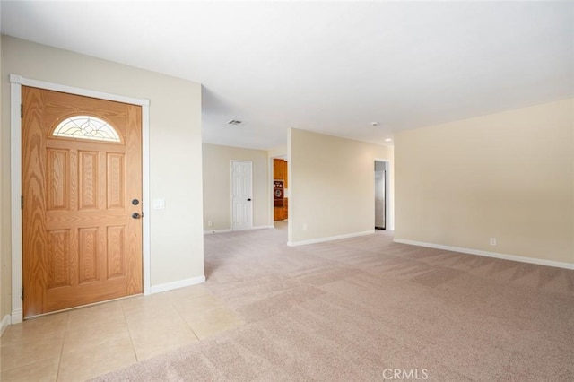 foyer entrance featuring light carpet, light tile patterned flooring, visible vents, and baseboards