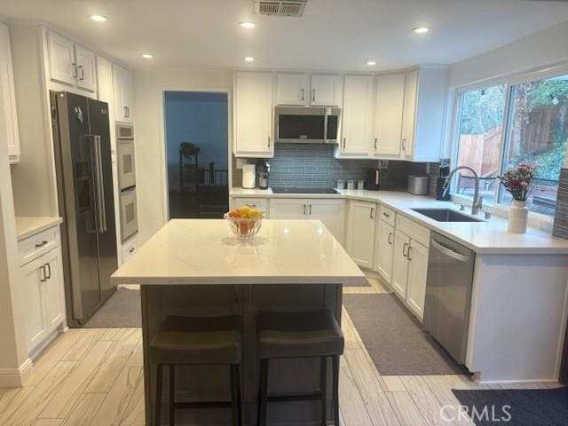 8373 Denise Ln, West Hills, CA 91304 - kitchen featuring appliances with stainless steel finishes, light countertops, white cabinets, and recessed lighting