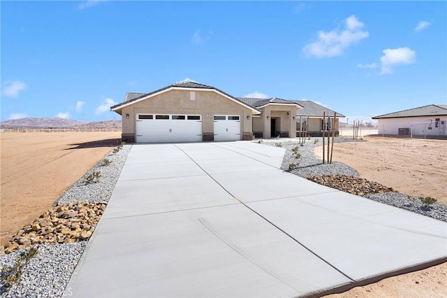 view of front of house with a garage, driveway, and stucco siding