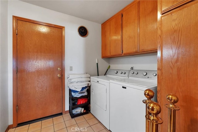 washroom featuring light tile patterned floors, washing machine and dryer, and cabinet space