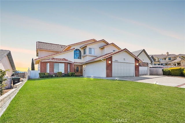 view of front of property featuring concrete driveway, a yard, and an attached garage