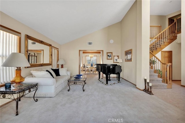 living area with high vaulted ceiling, light colored carpet, visible vents, and stairs