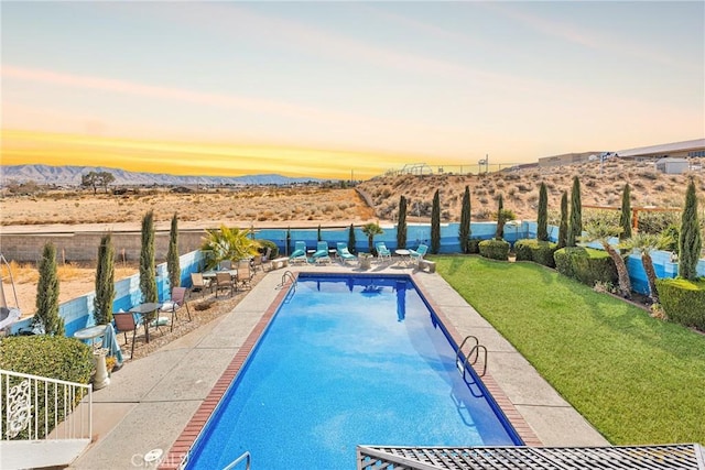 community pool featuring a yard, fence, and a mountain view