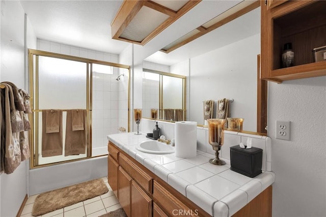 full bath with bath / shower combo with glass door, vanity, and tile patterned floors