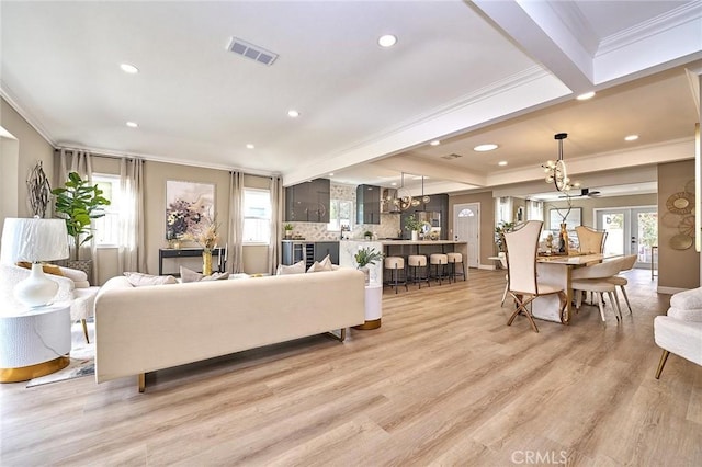 living room featuring ornamental molding, french doors, visible vents, and light wood finished floors