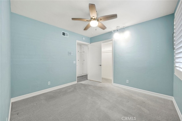 unfurnished bedroom with a closet, visible vents, light carpet, ceiling fan, and baseboards