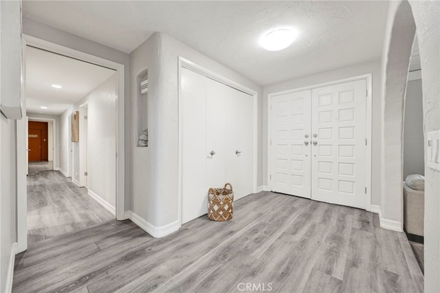 foyer entrance featuring light wood-style flooring and baseboards