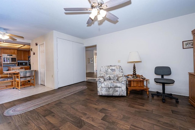 sitting room featuring baseboards, wood finished floors, and ceiling fan