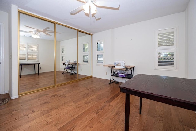home office featuring baseboards, a ceiling fan, and wood finished floors