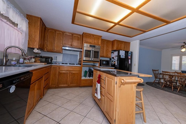kitchen with light tile patterned floors, a sink, black appliances, and a kitchen island
