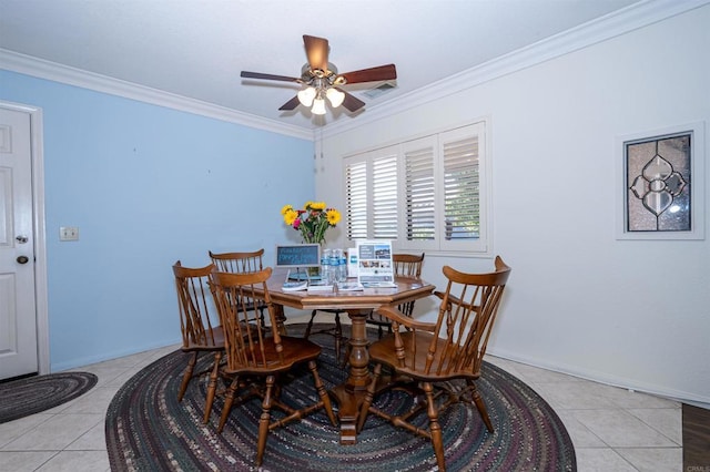 tiled dining space with crown molding, visible vents, baseboards, and a ceiling fan