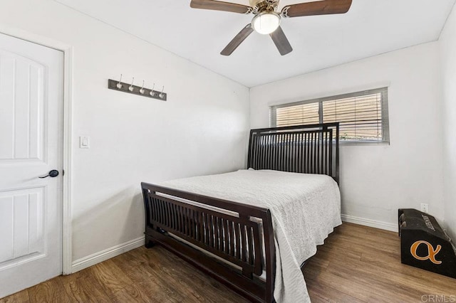 bedroom with dark wood-style floors, baseboards, and a ceiling fan