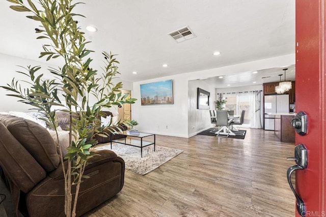 living area featuring dark wood-style floors, baseboards, visible vents, and recessed lighting