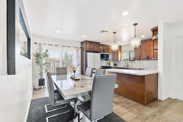 dining room with light wood-type flooring, visible vents, a chandelier, and recessed lighting