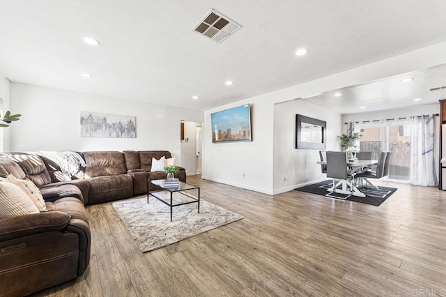 living room featuring recessed lighting, visible vents, baseboards, and wood finished floors