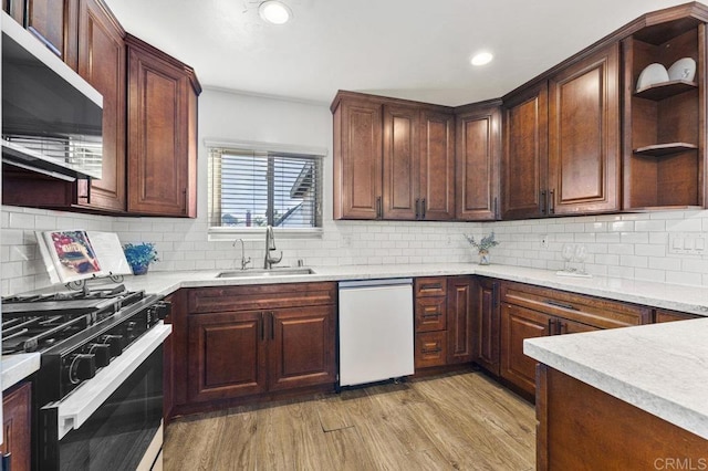 kitchen with a sink, range with gas stovetop, dishwasher, open shelves, and stainless steel microwave