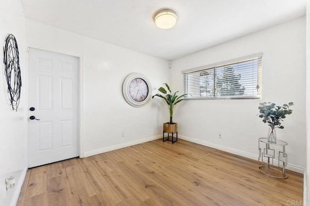 empty room with baseboards and light wood-style floors