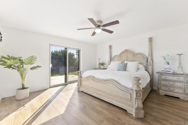 bedroom with access to outside, baseboards, and wood finished floors