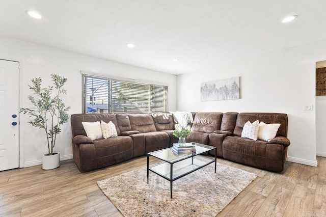 living area with light wood-type flooring, baseboards, and recessed lighting